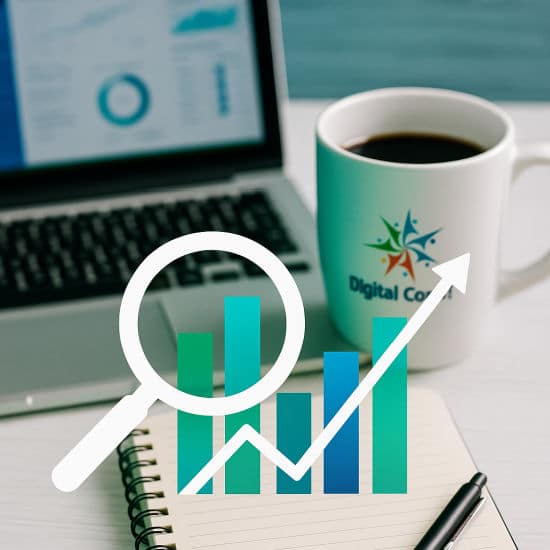 Coffee mug with the Digital Coach for Coaches logo on a desk beside a notepad and laptop, representing SEO and visibility check services.